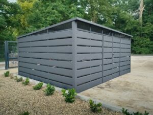 Wiata śmietnikowa o wymiarach 5x4m w panelowej zabudowie z blachy w kolorze matowy grafit z malowaną konstrukcją i niskim progiem